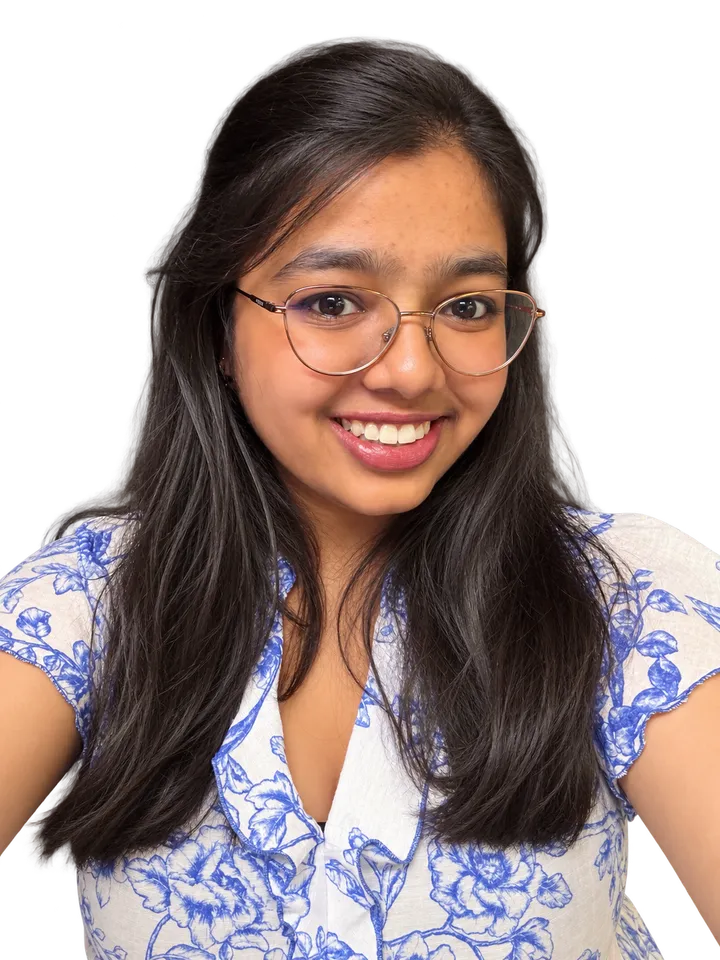 Harsha Gururaj smiling, in glasses and a blue floral top